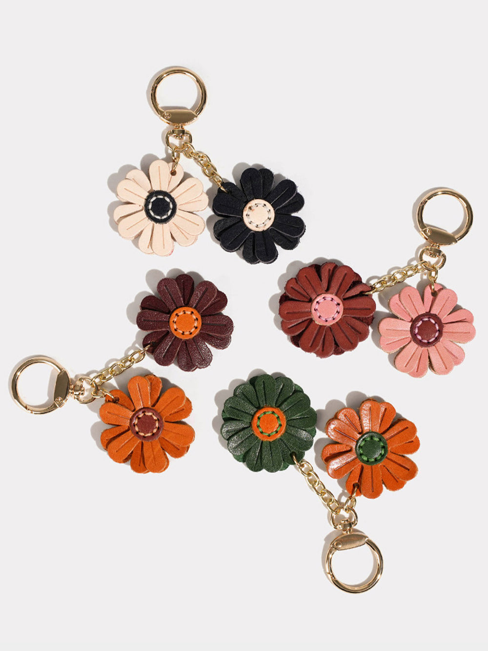 Small leather flower keychains with gold-tone metal rings and chains