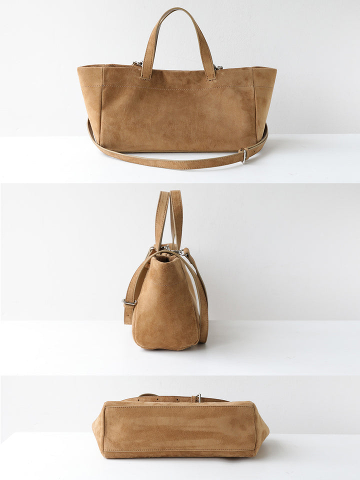 A tan suede tote bag shown from three angles on a white shelving display, featuring dual top handles, a detachable shoulder strap